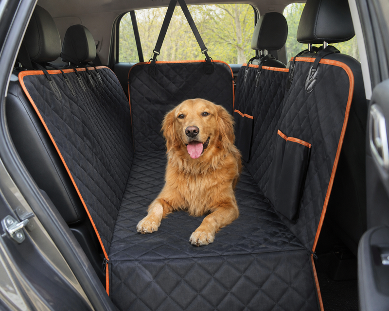 Golden retriever lying on the Back Seat Swag waterproof hammock fitted across the back seat of an SUV, showing the side flaps, storage pockets and headrest straps